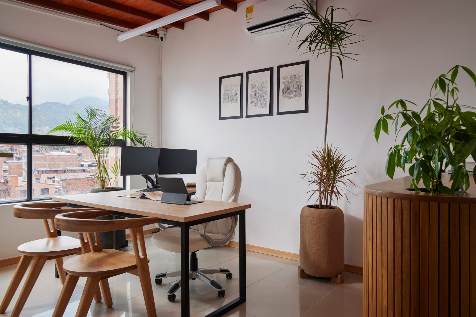Oficina luminosa con escritorio en madera y sillas de autor