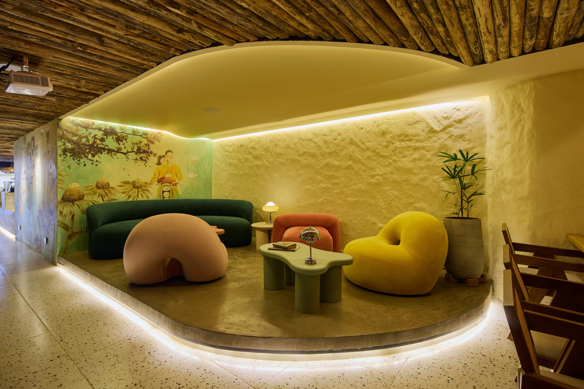 Sala lounge con sofás orgánicos en verde, ocre y rosa